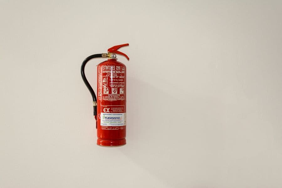 Wall-mounted red fire extinguisher for premises safety